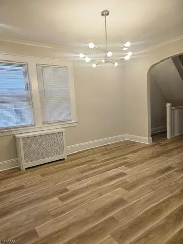 a view of a room with wooden floor and chandelier