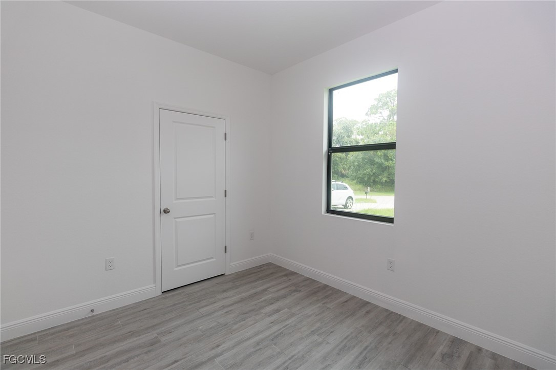 3032 West Briarwood Road LaBelle, FL 33935 - Photo 11 of 23 an empty room with wooden floor and windows