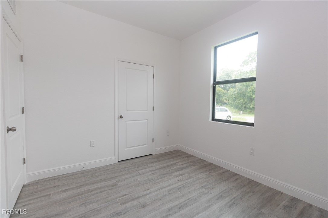 3032 West Briarwood Road LaBelle, FL 33935 - Photo 12 of 23 an empty room with wooden floor and windows