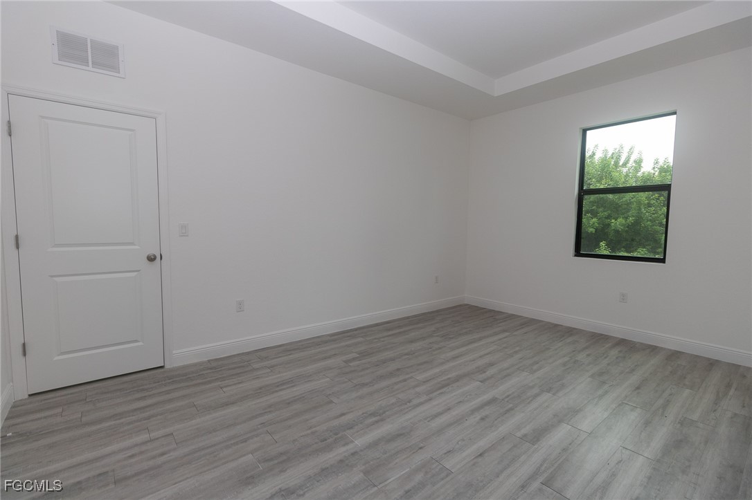 3032 West Briarwood Road LaBelle, FL 33935 - Photo 18 of 23 an empty room with wooden floor and windows