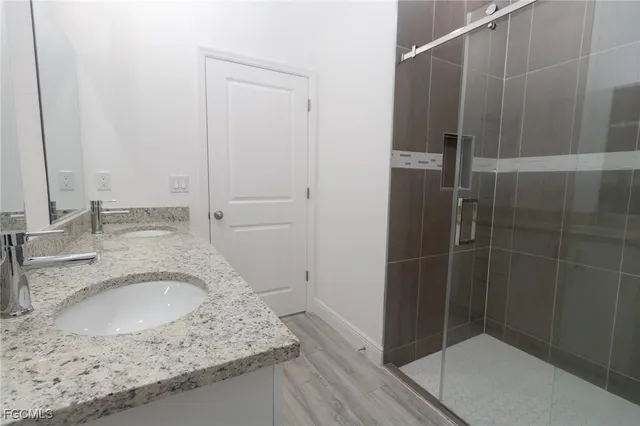 a bathroom with a granite countertop sink a toilet and shower
