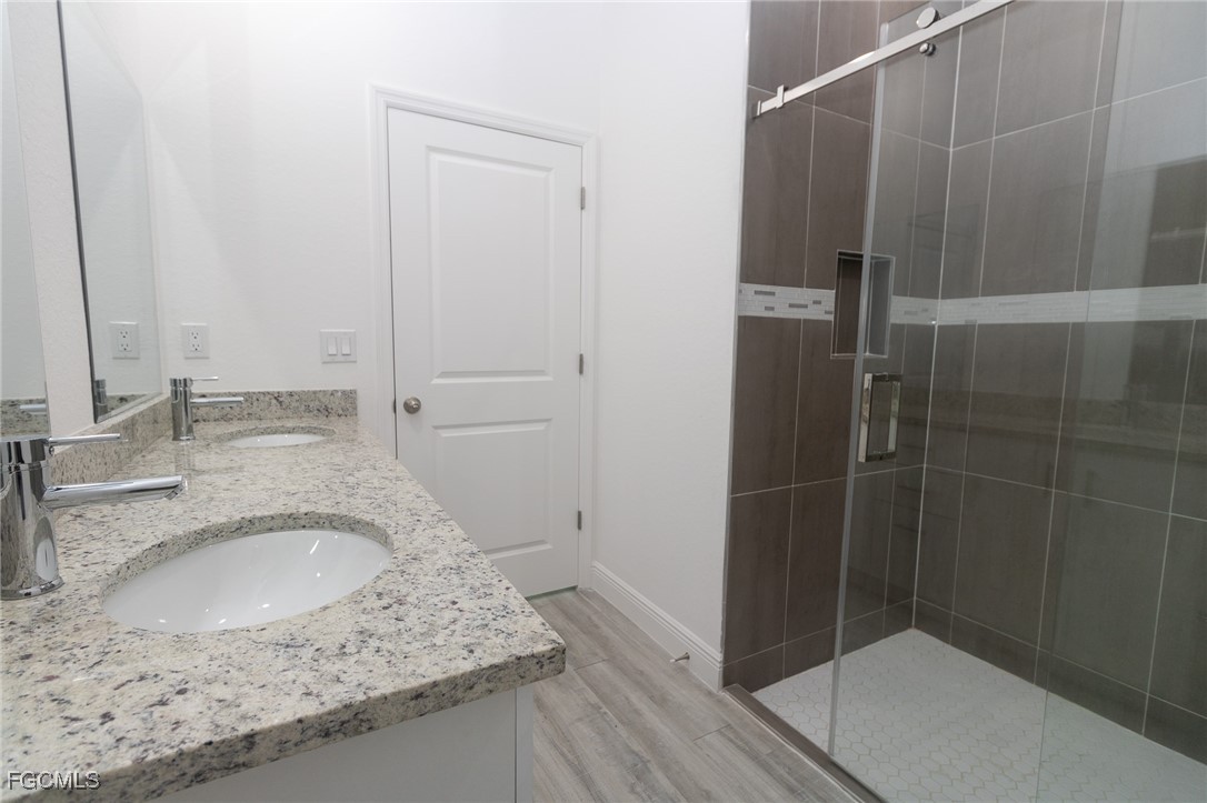 3032 West Briarwood Road LaBelle, FL 33935 - Photo 21 of 23 a bathroom with a granite countertop sink a toilet and shower