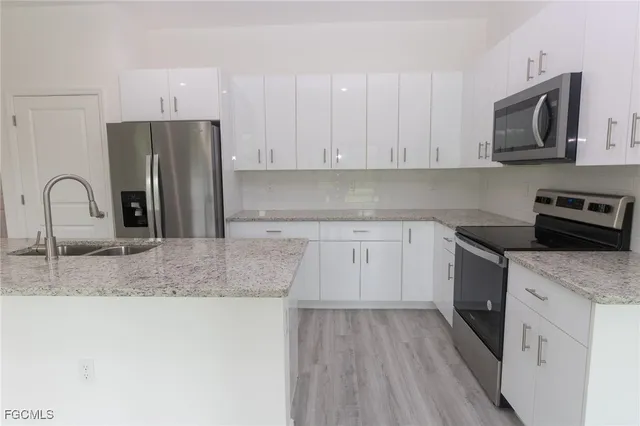 a kitchen with granite countertop a sink stove and refrigerator