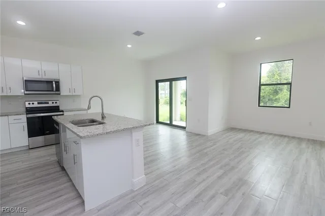 a kitchen with granite countertop a stove and a wooden floors