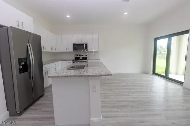 a kitchen with stainless steel appliances a refrigerator sink and stove