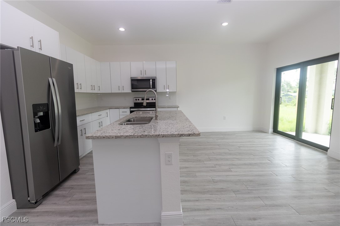 3032 West Briarwood Road LaBelle, FL 33935 - Photo 5 of 23 a kitchen with stainless steel appliances a refrigerator sink and stove