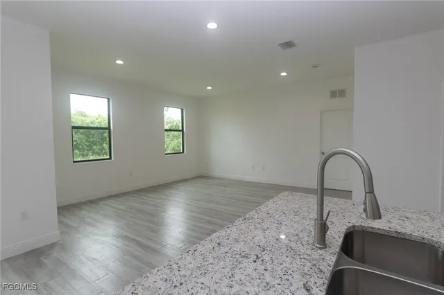 a view of a kitchen with granite countertop stainless steel appliances and a sink