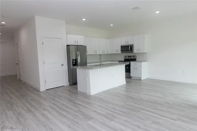 a kitchen with stainless steel appliances a refrigerator and a stove top oven
