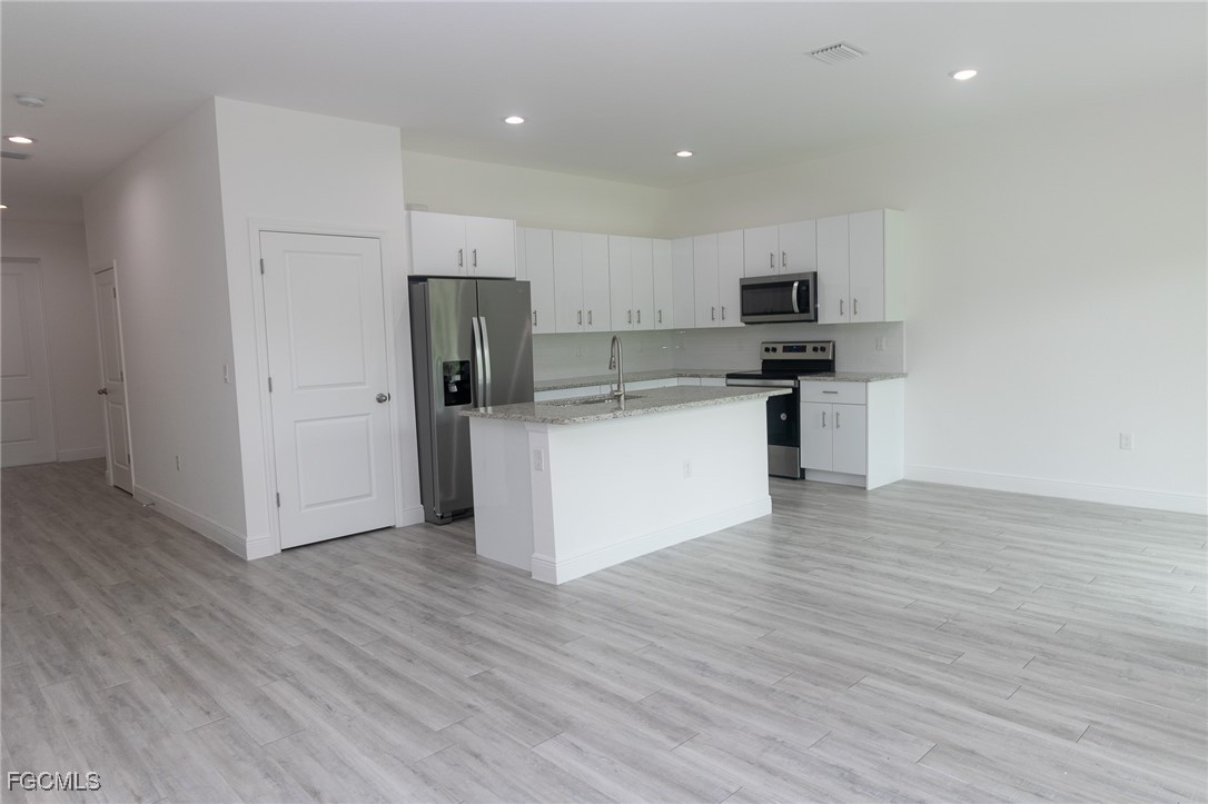 3032 West Briarwood Road LaBelle, FL 33935 - Photo 8 of 23 a kitchen with stainless steel appliances a refrigerator and a stove top oven