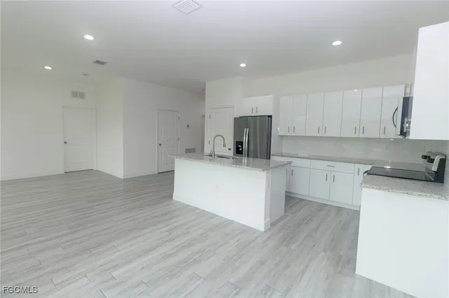 a kitchen with a sink wooden floor and white cabinets