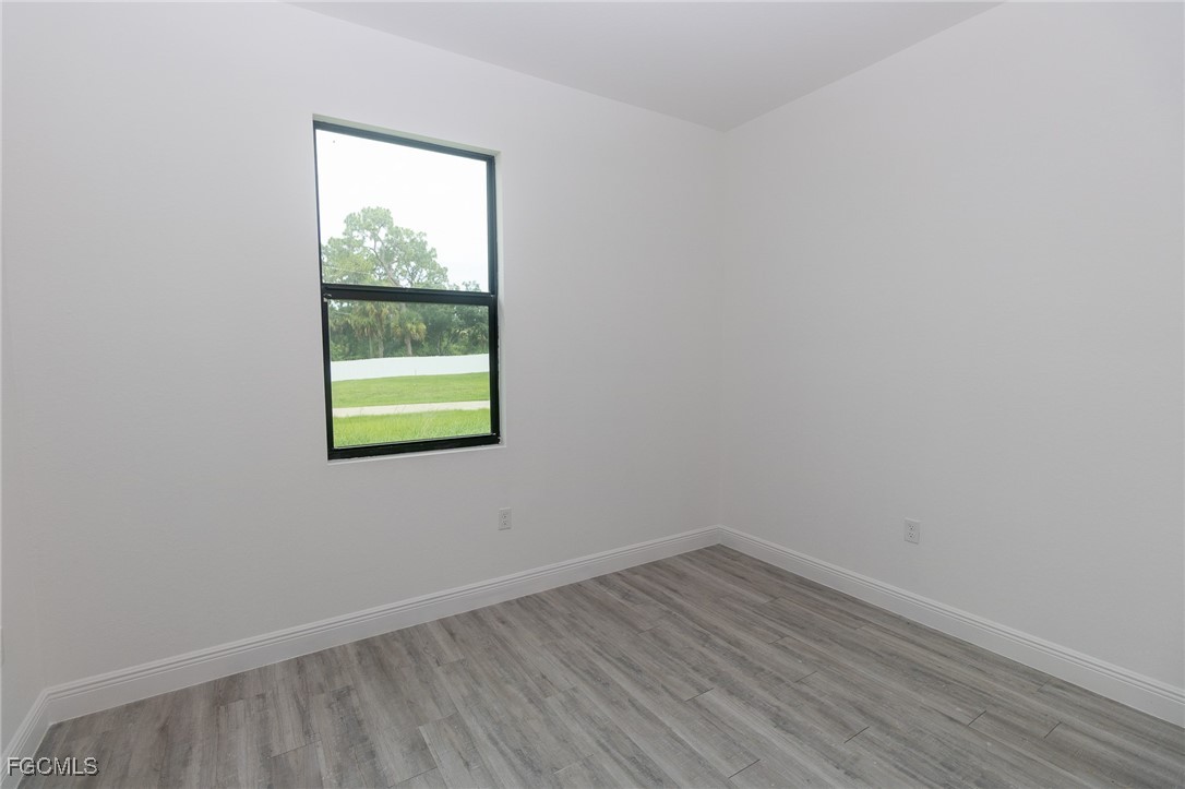 3032 West Briarwood Road LaBelle, FL 33935 - Photo 10 of 23 a view of an empty room with wooden floor and a window