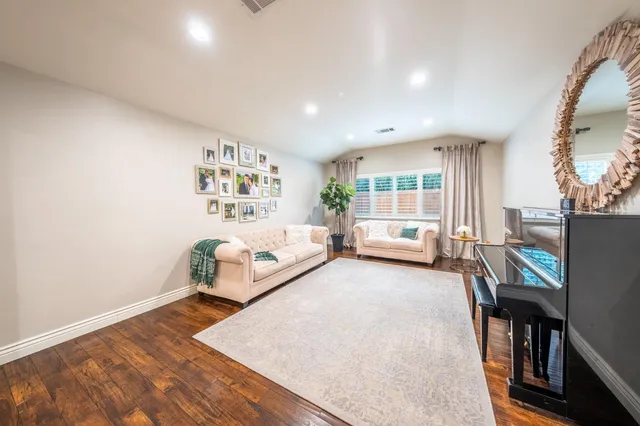 a view of a dining room and livingroom with furniture wooden floor a chandelier