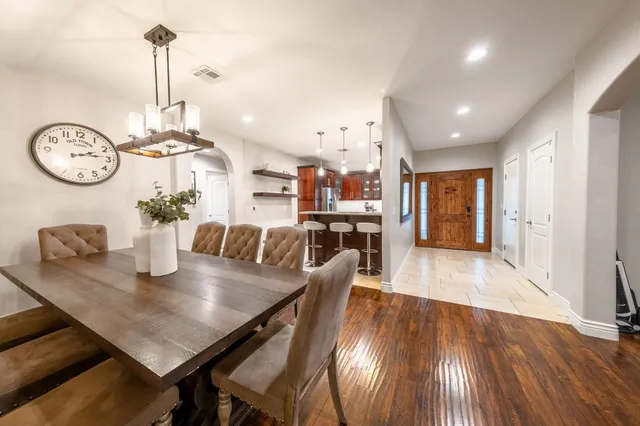 a view of a dining room and livingroom with furniture wooden floor a chandelier