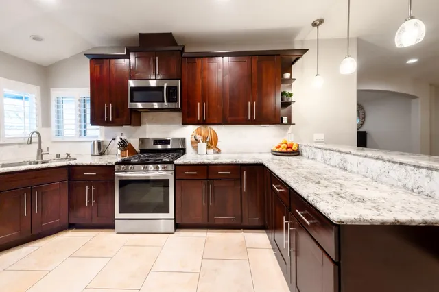 a bedroom with a large bed chandelier and a window