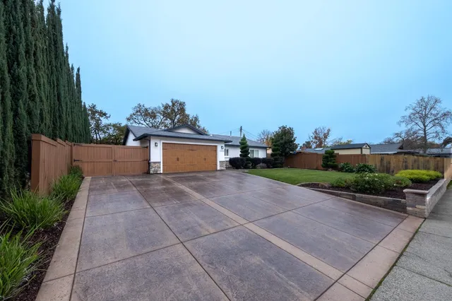 a front view of a house with a yard and potted plants