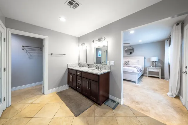 a spacious bedroom with a bed and wooden floor