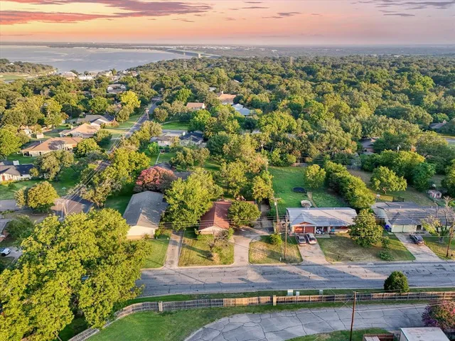 an aerial view of residential houses with outdoor space and trees