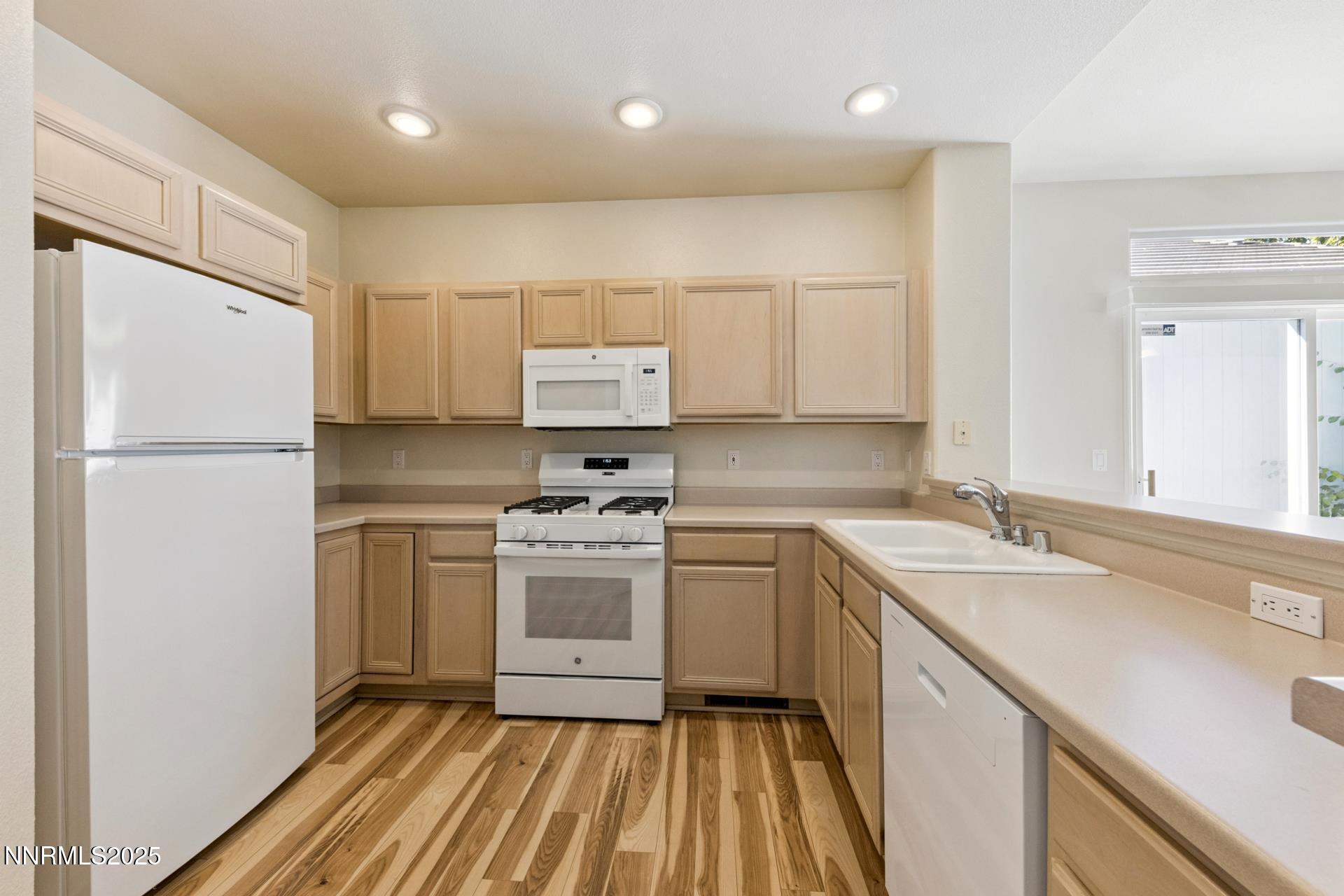 709 Caughlin Glen Reno, NV 89519 - Photo 4 of 41 a kitchen with a sink a refrigerator a window and white cabinets