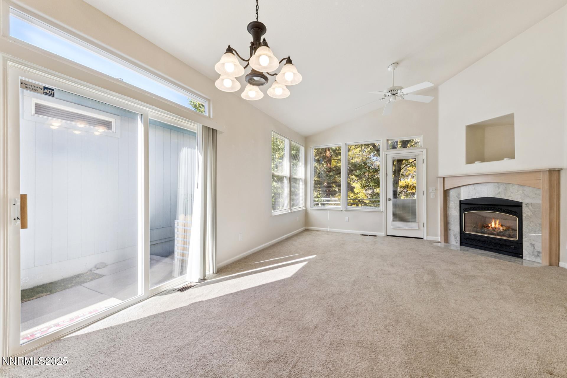 709 Caughlin Glen Reno, NV 89519 - Photo 9 of 41 a view of a livingroom with a fireplace large windows and a chandelier