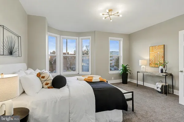 a bedroom with a bed gym equipment and a large window