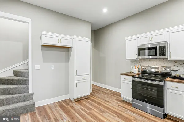 a kitchen with granite countertop a stove and a microwave