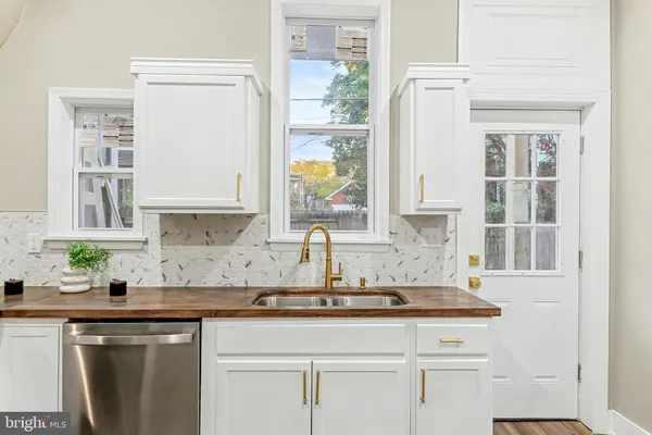 a kitchen with stainless steel appliances granite countertop a sink a window and cabinets