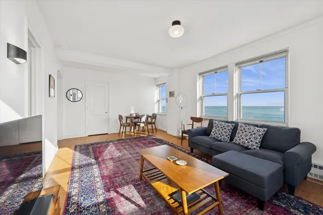 a living room with furniture a rug and a large window