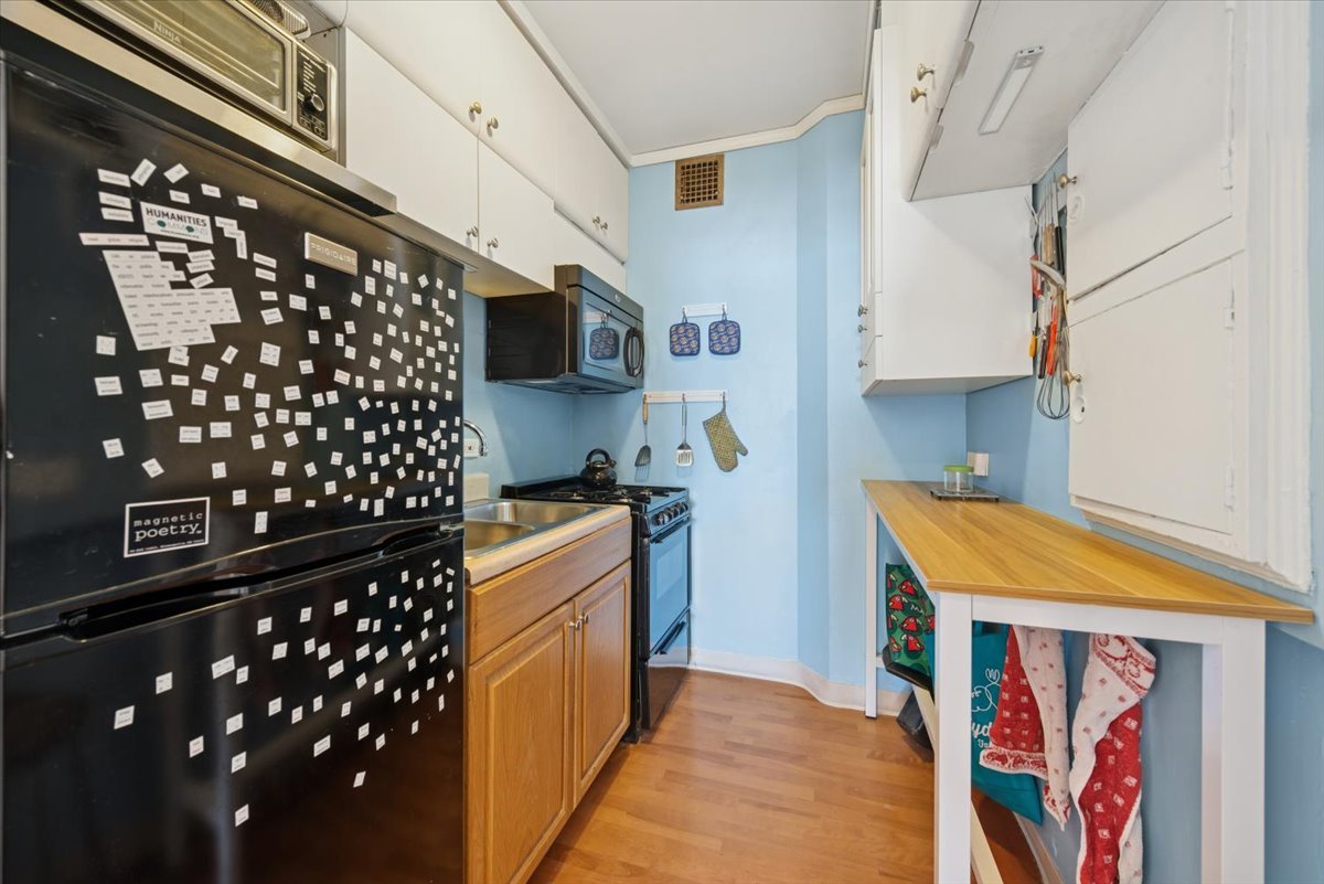 5555 North Sheridan Road, Unit 1716 Chicago, IL 60640 - Photo 10 of 24 a kitchen with granite countertop a black refrigerator oven a sink and dishwasher