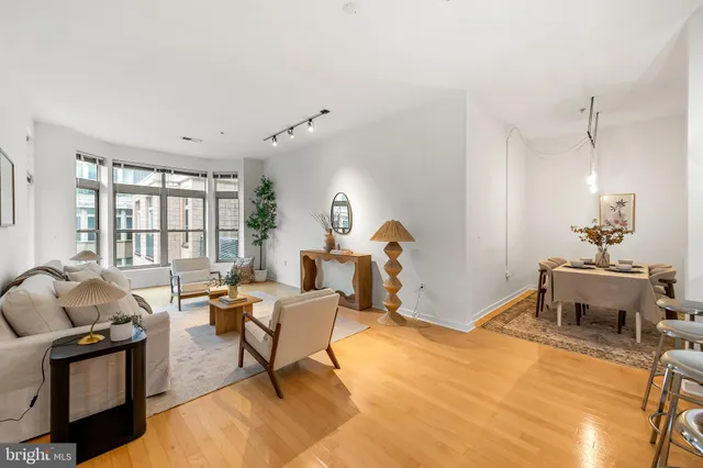 a living room with furniture a table and large windows
