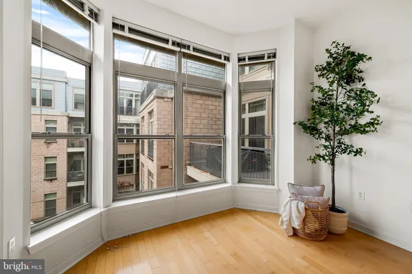 a view of an empty room with a large window and potted plants