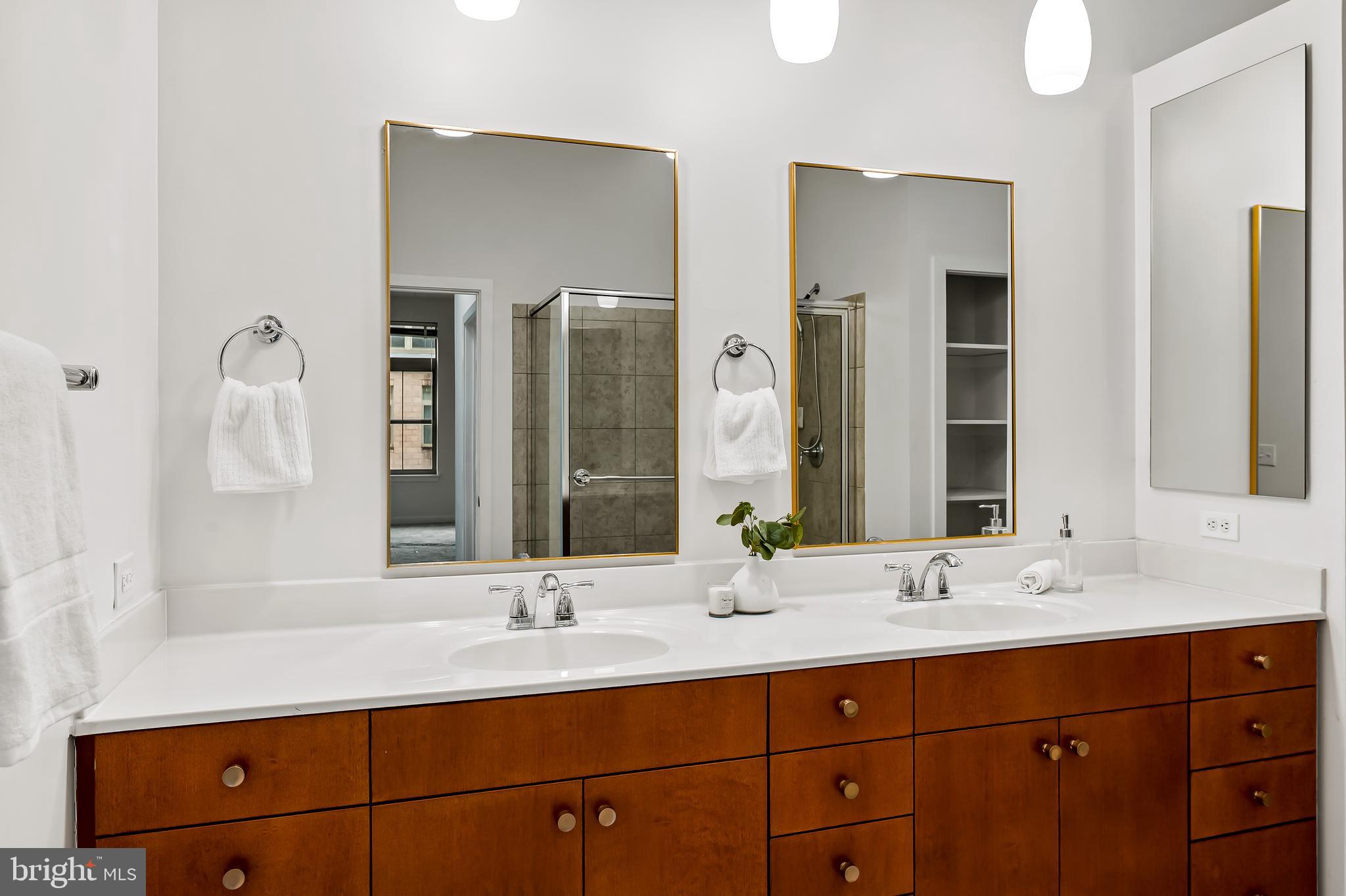 1209 North Charles Street, Unit 314 Baltimore, MD 21201 - Photo 24 of 34 a bathroom with double vanity sinks and a mirror