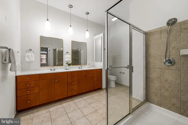 a bathroom with a double vanity sink toilet and shower