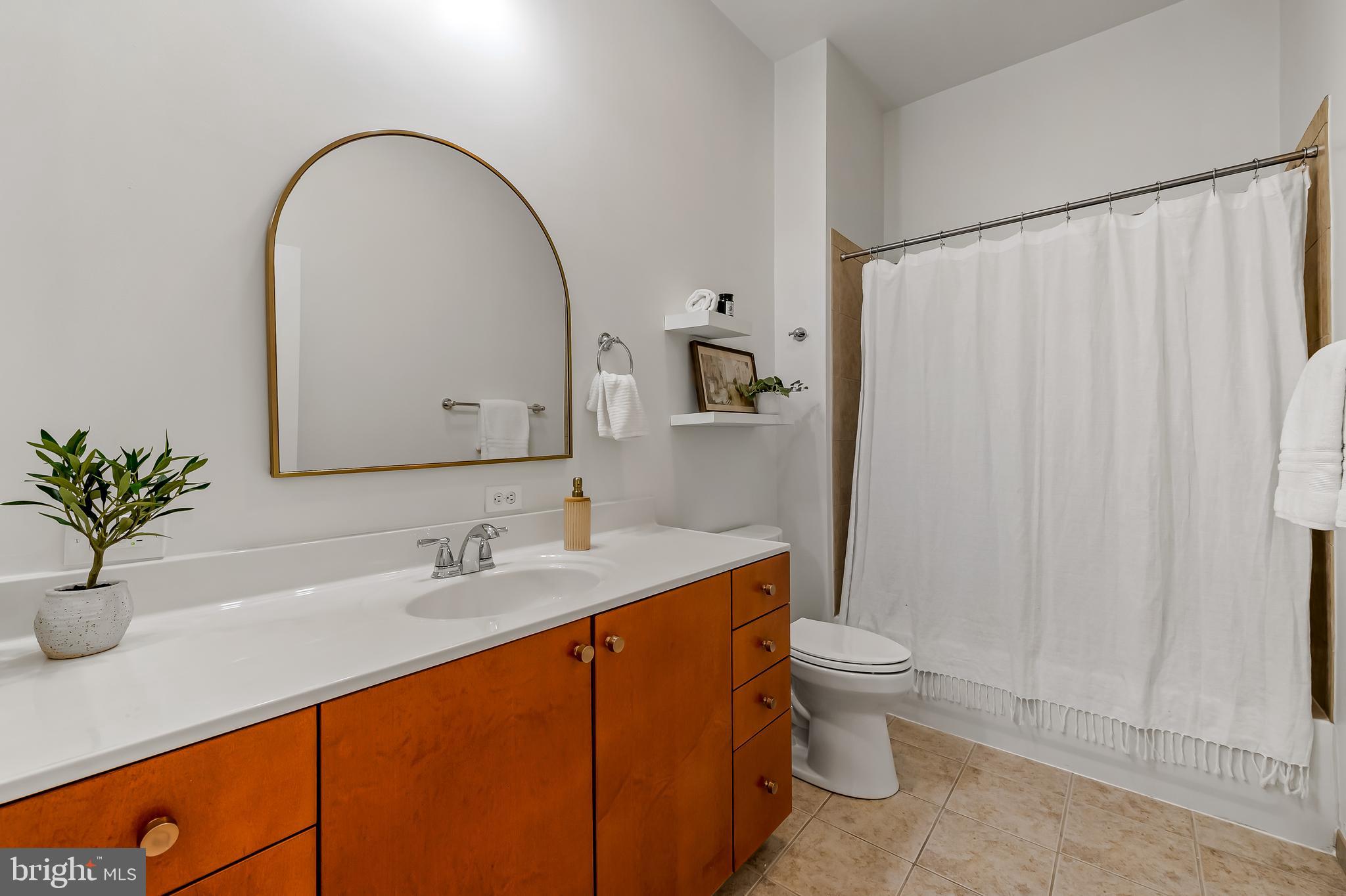 1209 North Charles Street, Unit 314 Baltimore, MD 21201 - Photo 28 of 34 a bathroom with a sink a toilet and a mirror
