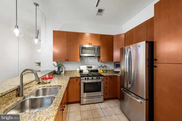 a kitchen with granite countertop a refrigerator and a sink