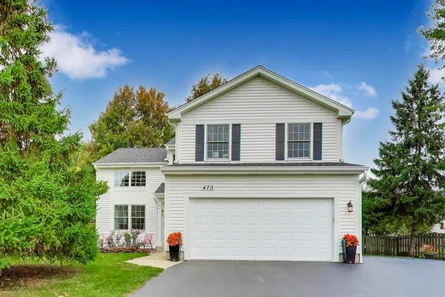 a view of a house with a yard and garage
