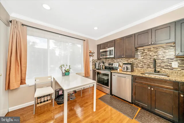 a kitchen with a table chairs microwave and cabinets