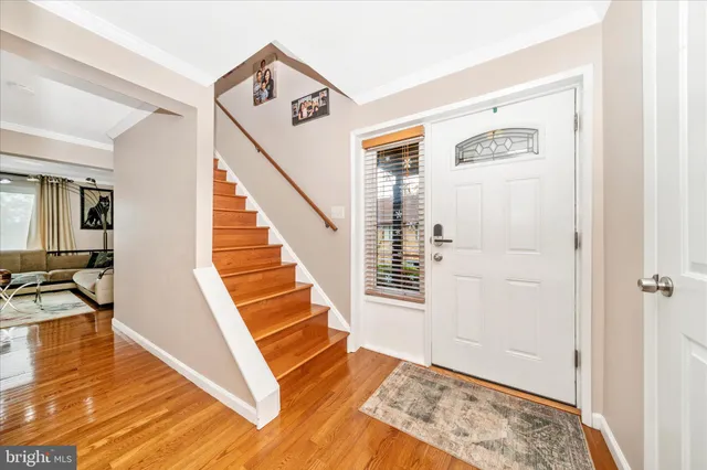 a view of a hallway with wooden floor and staircase