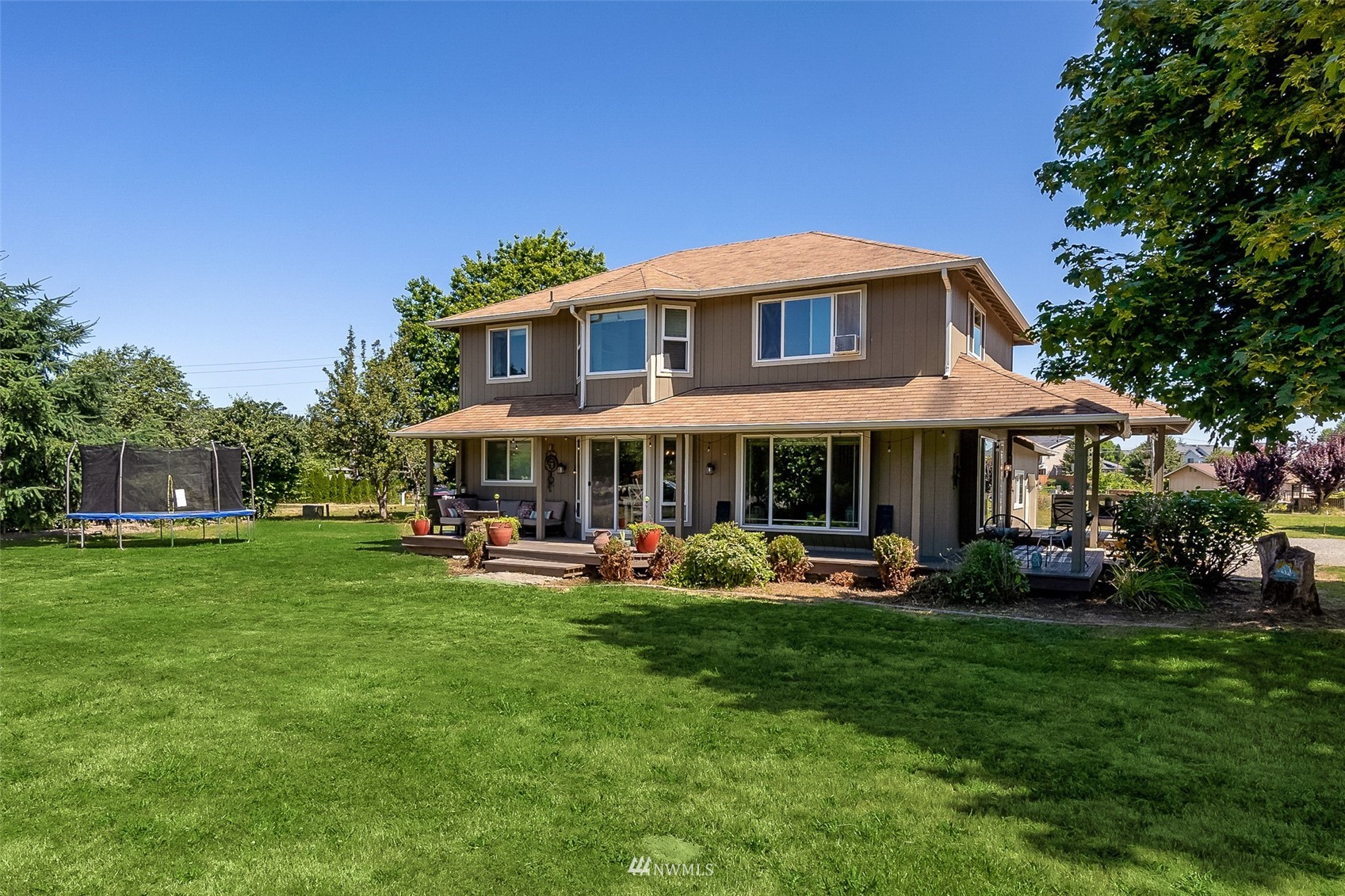 a front view of a house with garden and sitting area