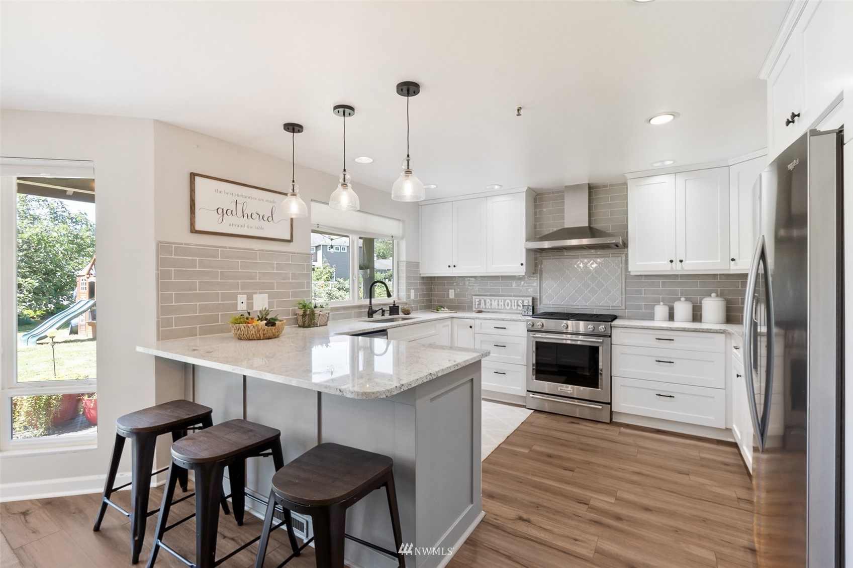 21847 Frager Road South Kent, WA 98032 - Photo 12 of 34 a kitchen with stainless steel appliances kitchen island a table chairs and a refrigerator