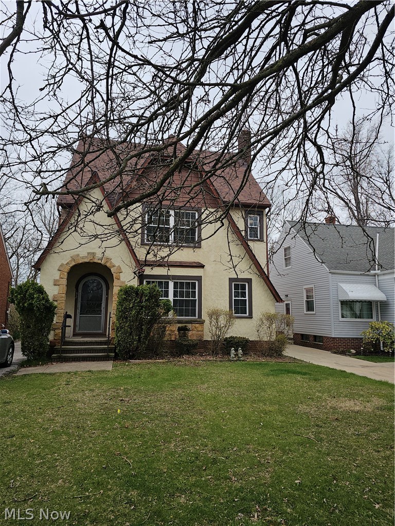 832 Hoover Road Cleveland, OH 44119 - Photo 2 of 10 English style home with a front lawn, a chimney, stucco siding, and stone siding