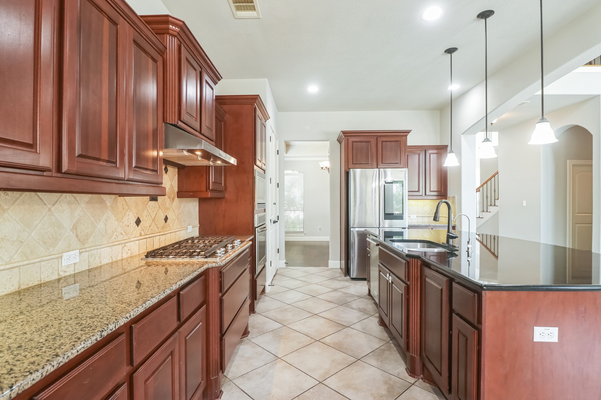 3913 Remington Road Cedar Park, TX 78613 - Photo 11 of 32 Gleaming stone countertops and rich wooden cabinetry anchor this well-appointed kitchen.
