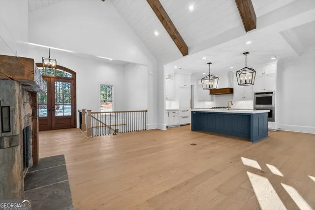a kitchen with stainless steel appliances granite countertop a sink a stove and a wooden floors