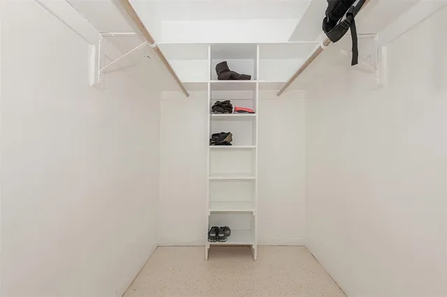 a view of walk in closet with empty racks