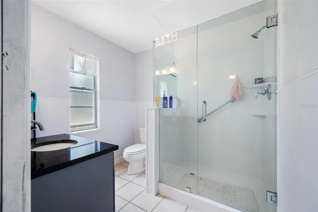 a bathroom with a sink a toilet a mirror and shower