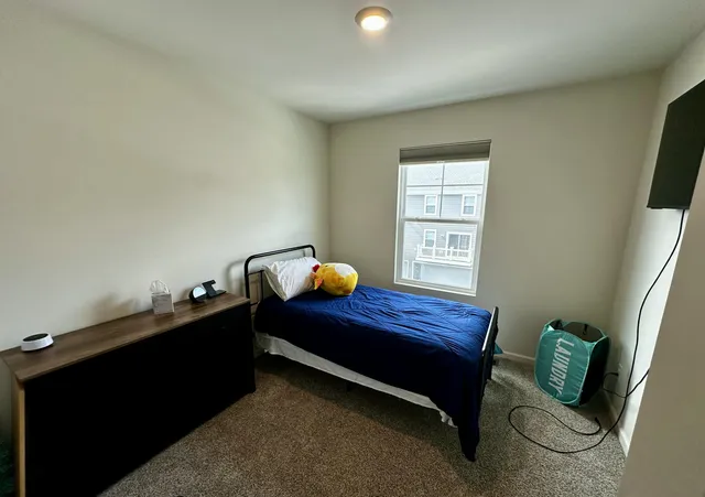 a bed sitting in a bedroom next to a window