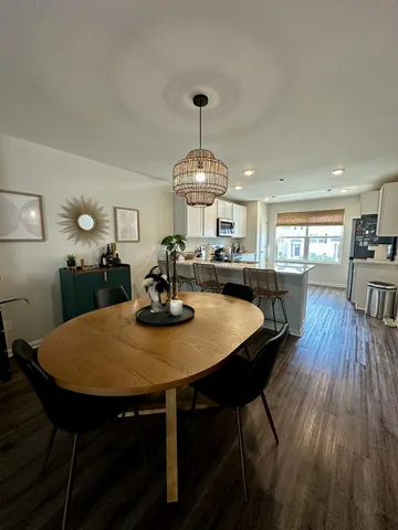 a view of a dining room and livingroom with furniture wooden floor a chandelier