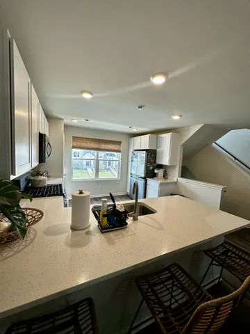 a kitchen with sink and view of living room