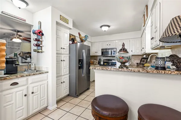 a kitchen with stainless steel appliances a sink cabinets and wooden floor