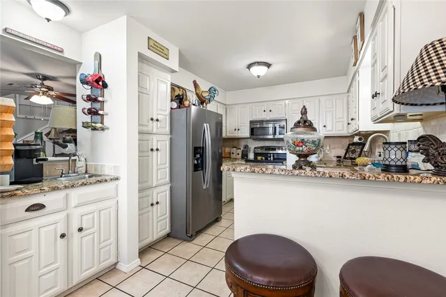 a kitchen with stainless steel appliances a sink cabinets and wooden floor