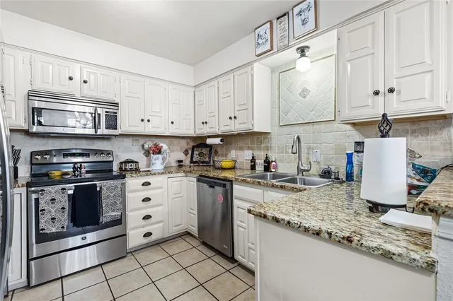 a kitchen with granite countertop a stove sink and cabinets
